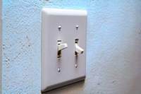 A wall switch with two switches: one flipped up and one flipped down.
