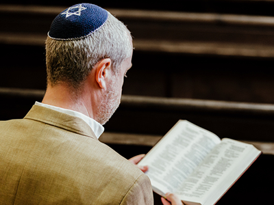 Jewish man sitting in a church reading a religious book