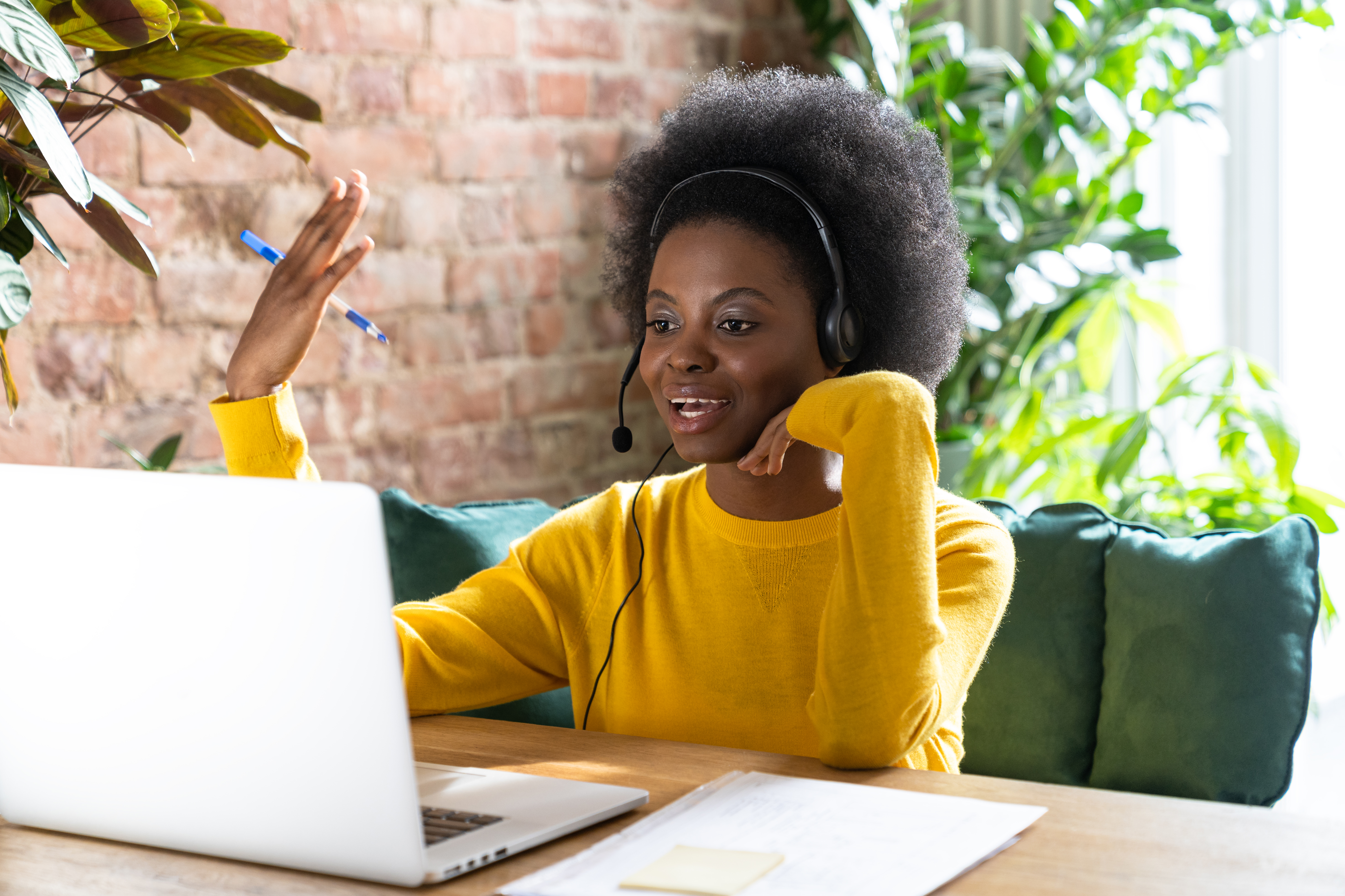 Woman sitting on a laptop with a headset talking to a customer