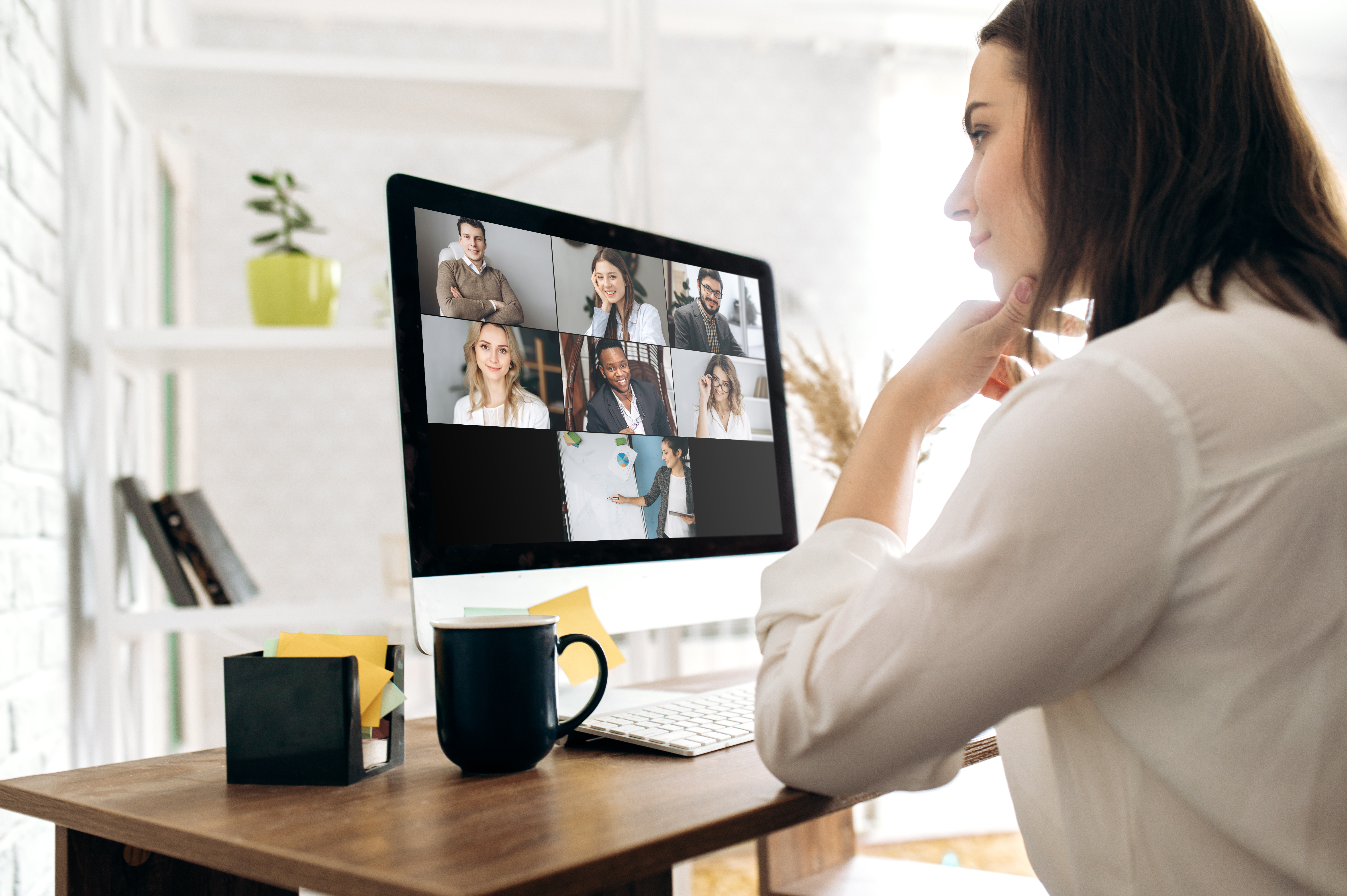 Woman on a desktop computer in a video meeting with co-workers